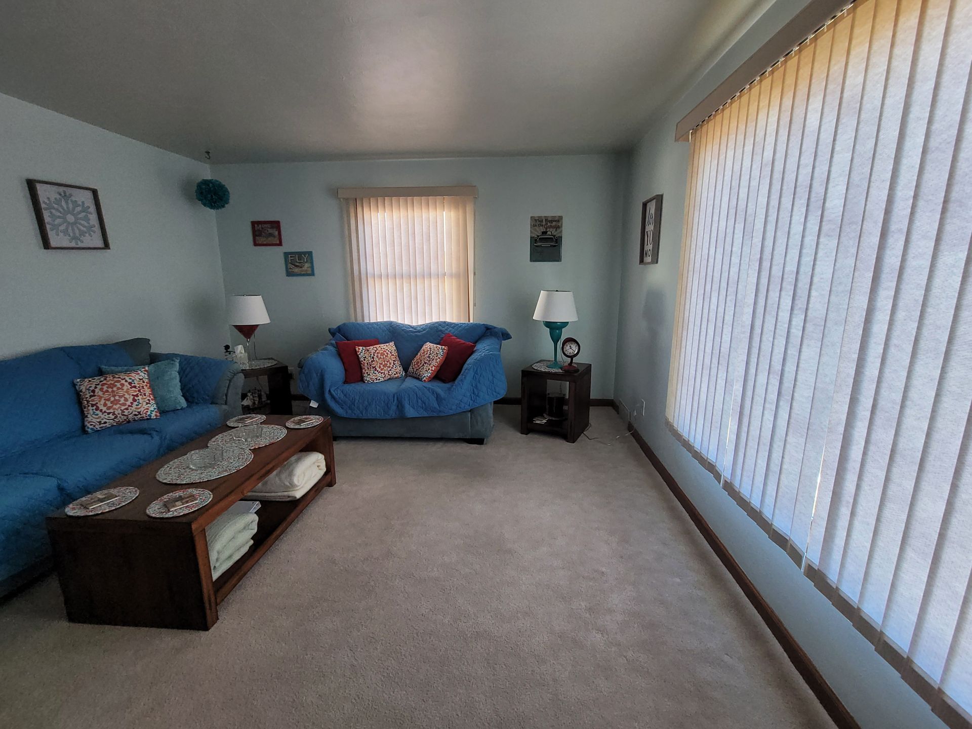 A living room with a blue couch and a coffee table