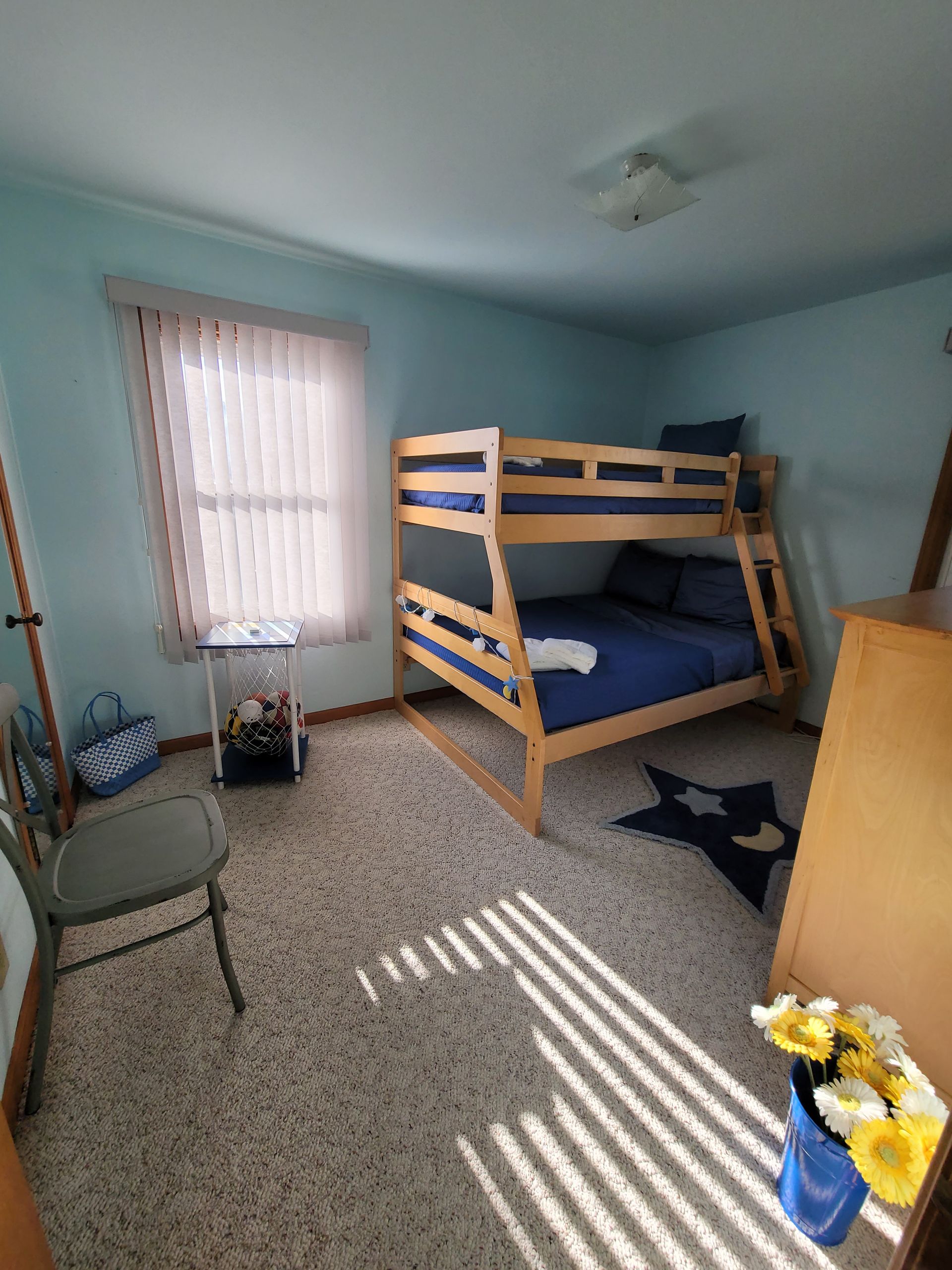 A bedroom with a bunk bed and a window.