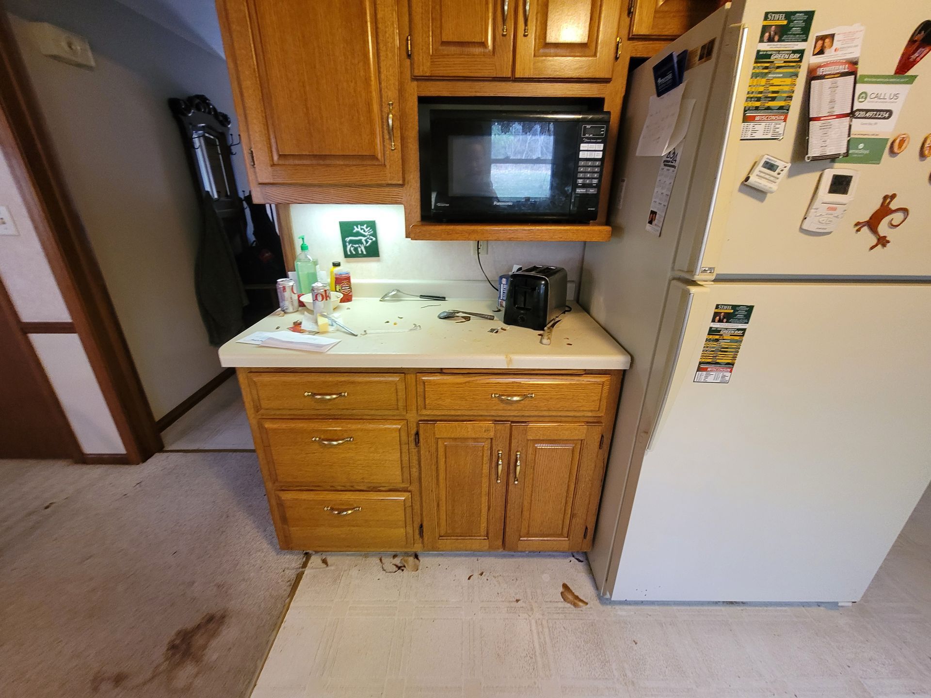 A kitchen with wooden cabinets and a white refrigerator
