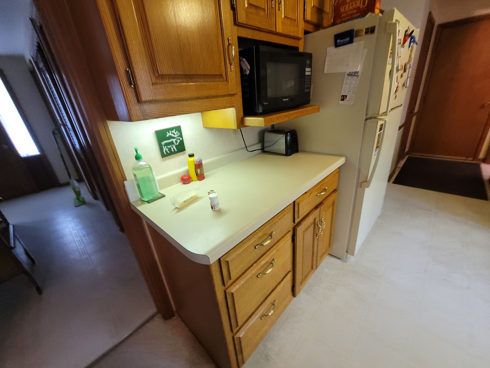 A kitchen with wooden cabinets and a white refrigerator