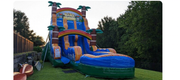 A large, inflatable blue, orange, and green tropical-themed water slide set up on a grassy lawn.