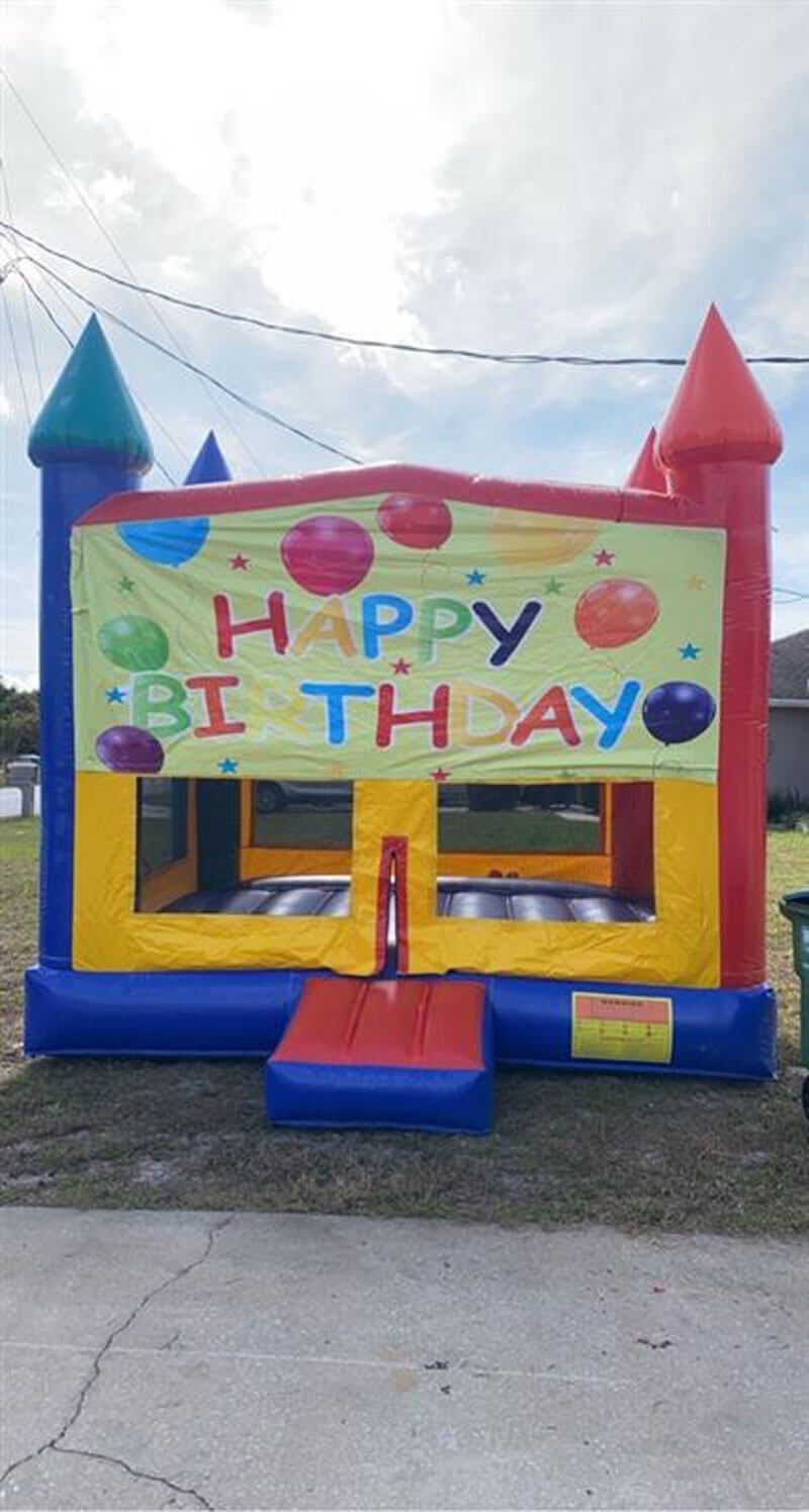A colorful, inflatable bounce house outdoors with a 