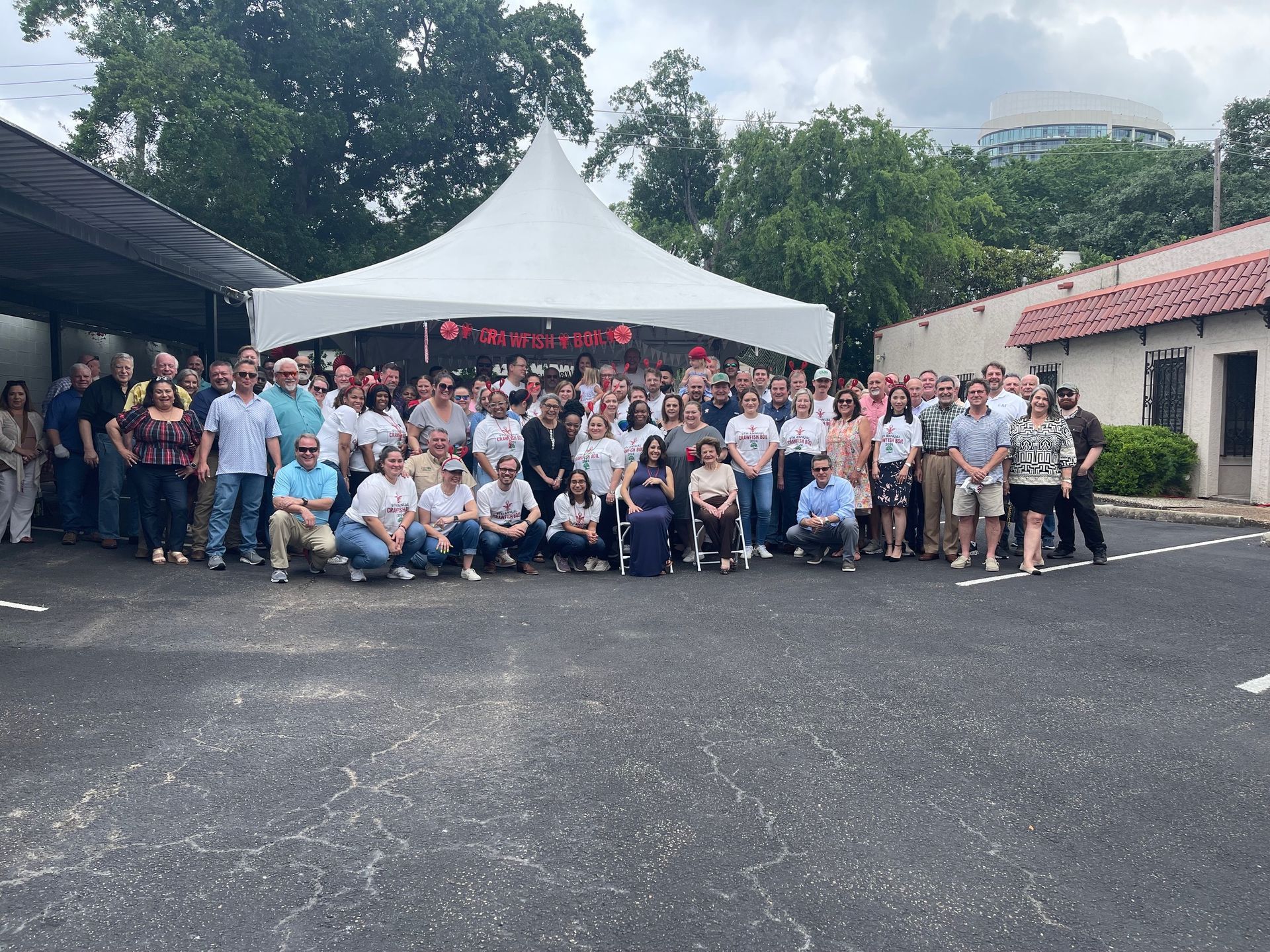 A large group of people are posing for a picture in front of a tent.
