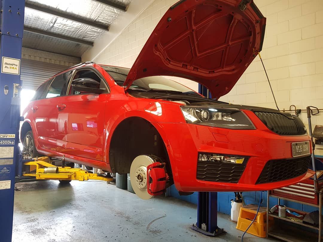 A Red Car with The Hood up Is on A Lift in A Garage — Latin Motors in Fyshwick, ACT