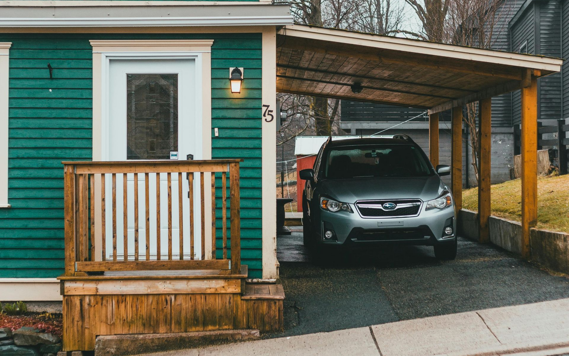 Attached wooden carport for residential driveway vehicle shade.