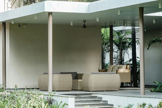 Modern white concrete patio cover with outdoor lounge furniture.