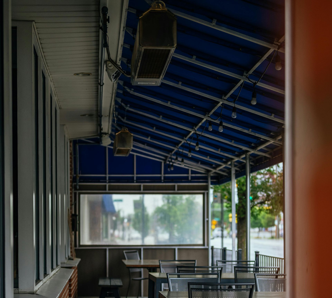 Blue commercial awning over a lit outdoor dining area.