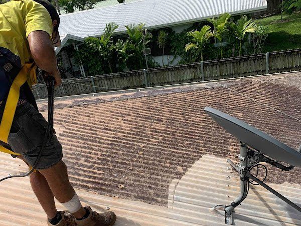 A man with a backpack is standing on a roof.