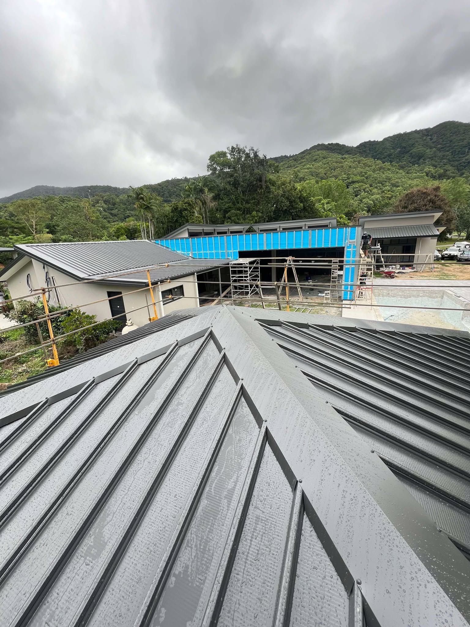 A man with a backpack is standing on a roof.