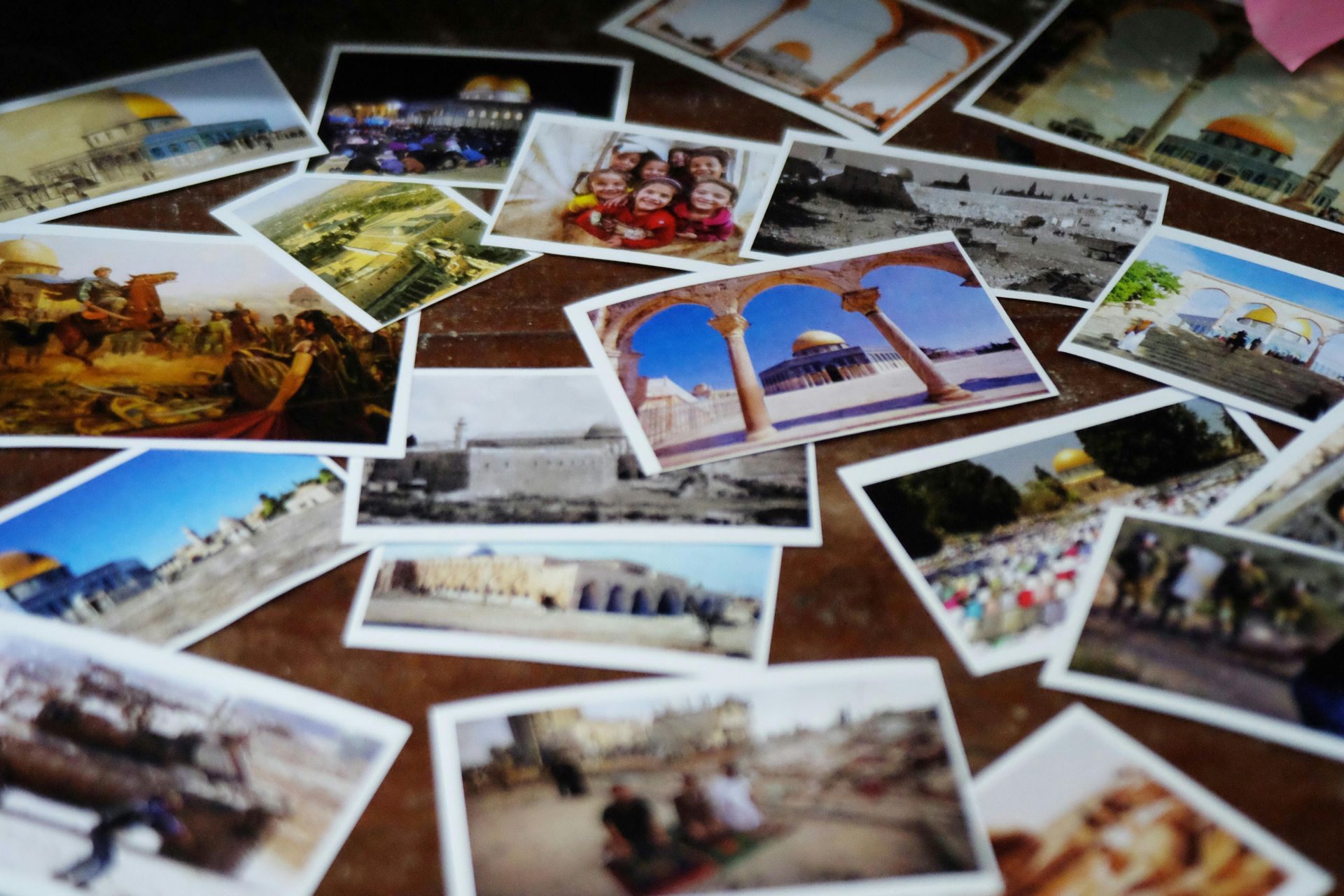 Photos of Middle Eastern landmarks scattered on a surface.