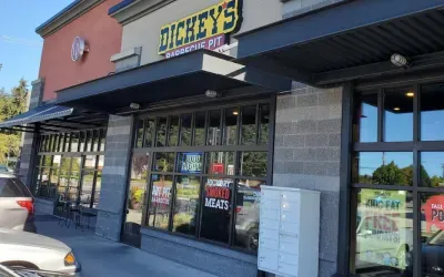 Dickey's Barbecue Pit restaurant exterior with signs, awning, and glass windows.