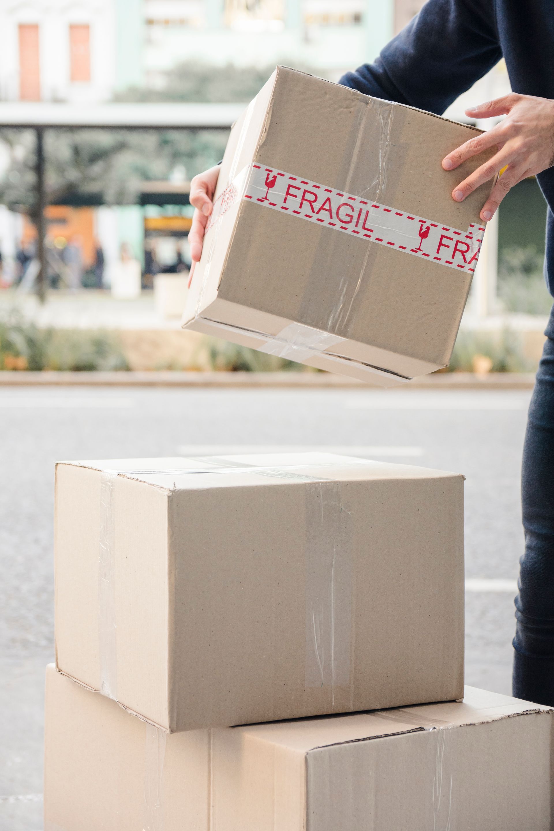 Persona colocando una caja de cartón etiquetada como 