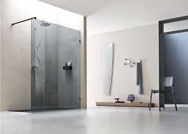 Bagno moderno con box doccia in vetro, portasciugamani, specchio e panca in un interno minimalista sui toni del grigio.