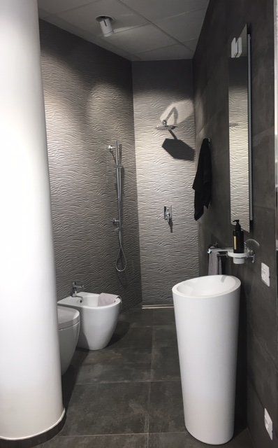 Cabina bagno moderna con WC, orinatoio, lavabo e appendiabiti a parete.
