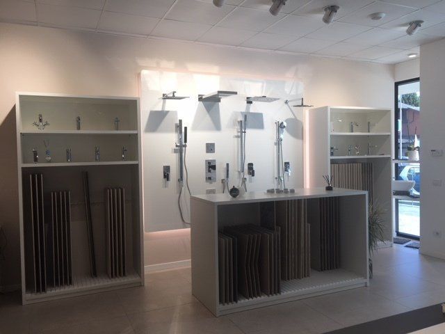 Showroom moderno con vetrine bianche, applique a parete e illuminazione a incasso.