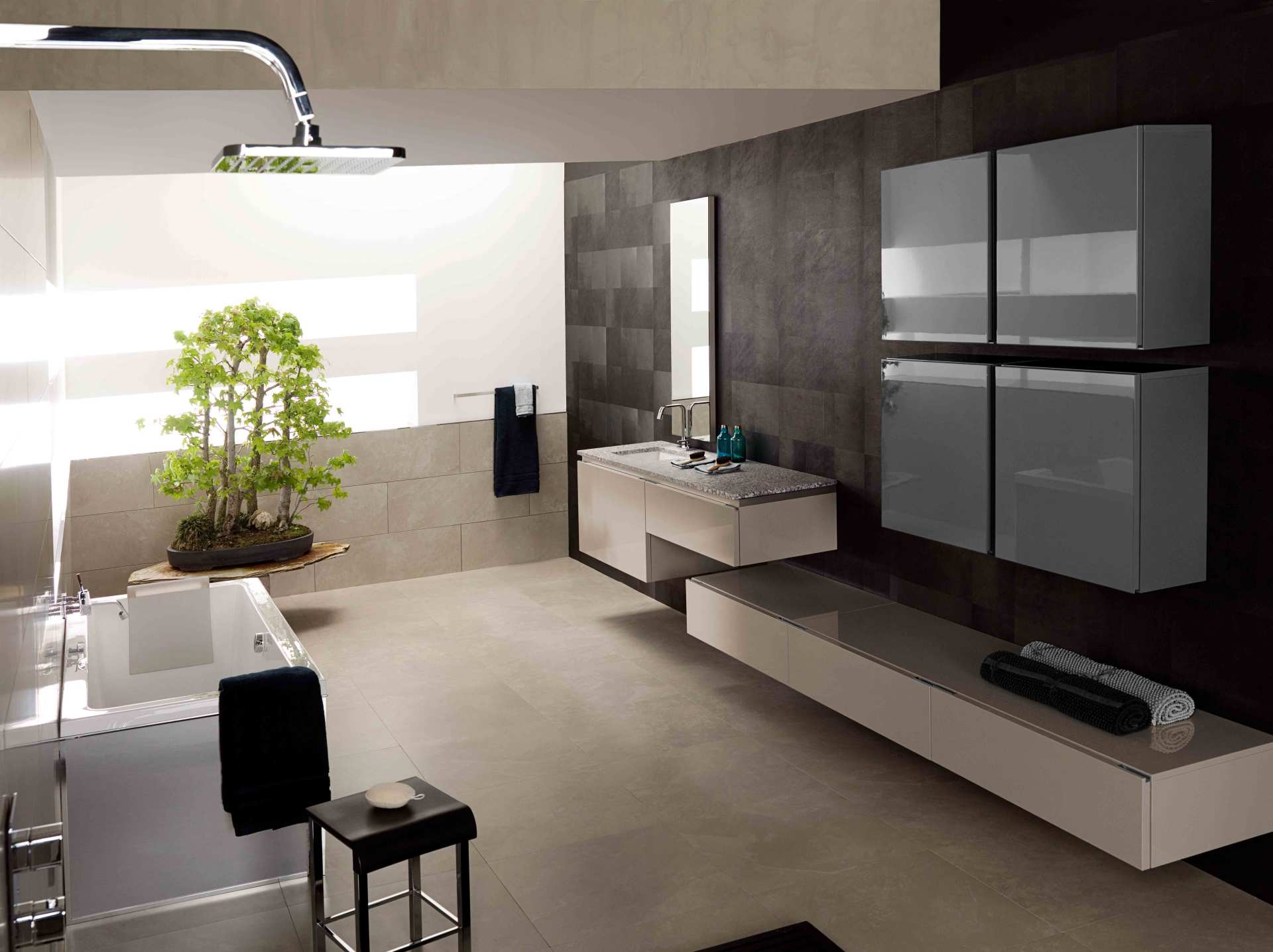 Bagno moderno e minimalista con mobile lavabo sospeso, ampi armadietti con specchio e una pianta in vaso vicino alla vasca.