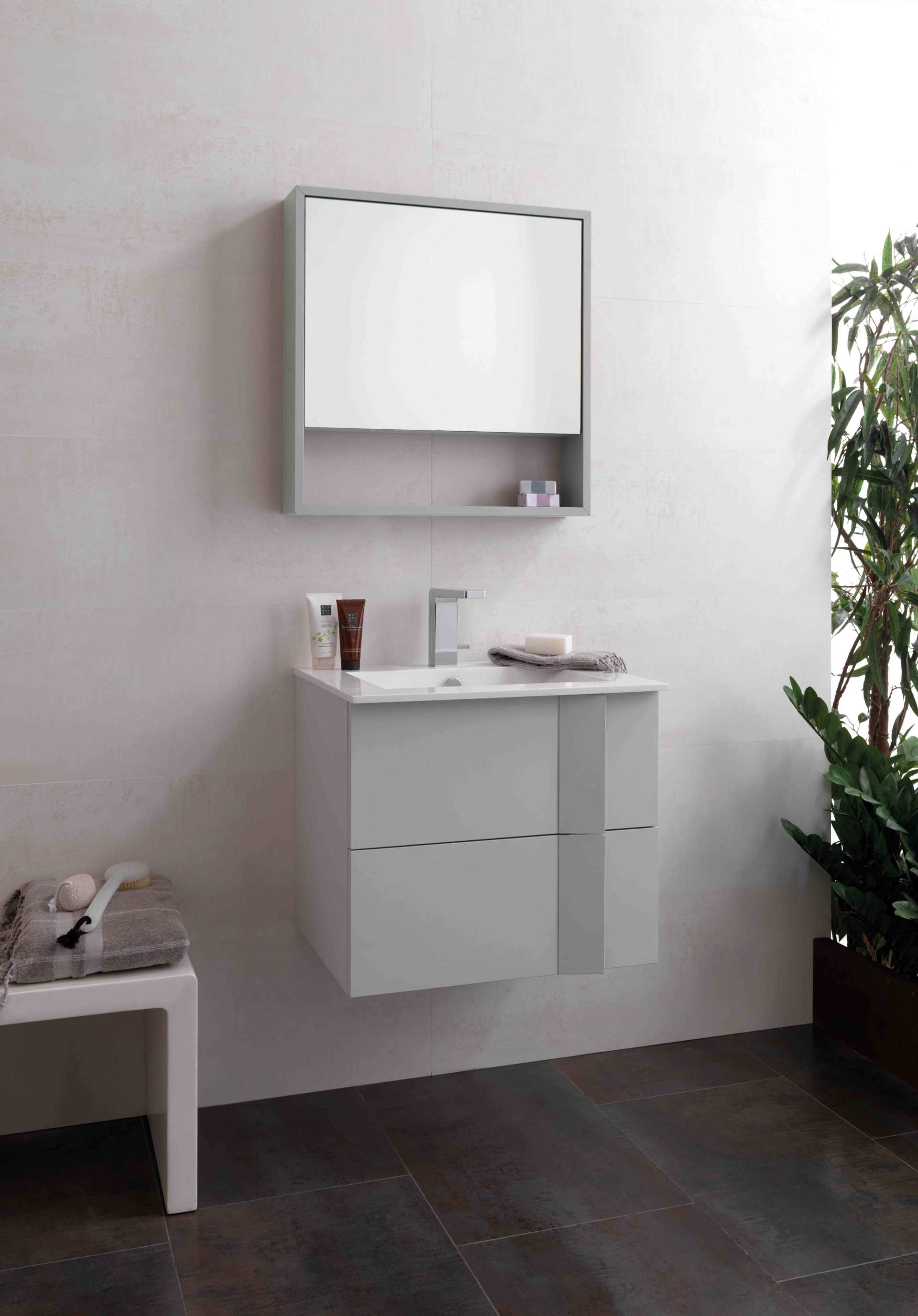 Moderno mobile da bagno bianco con specchio, lavabo e pianta accanto a un pavimento scuro.