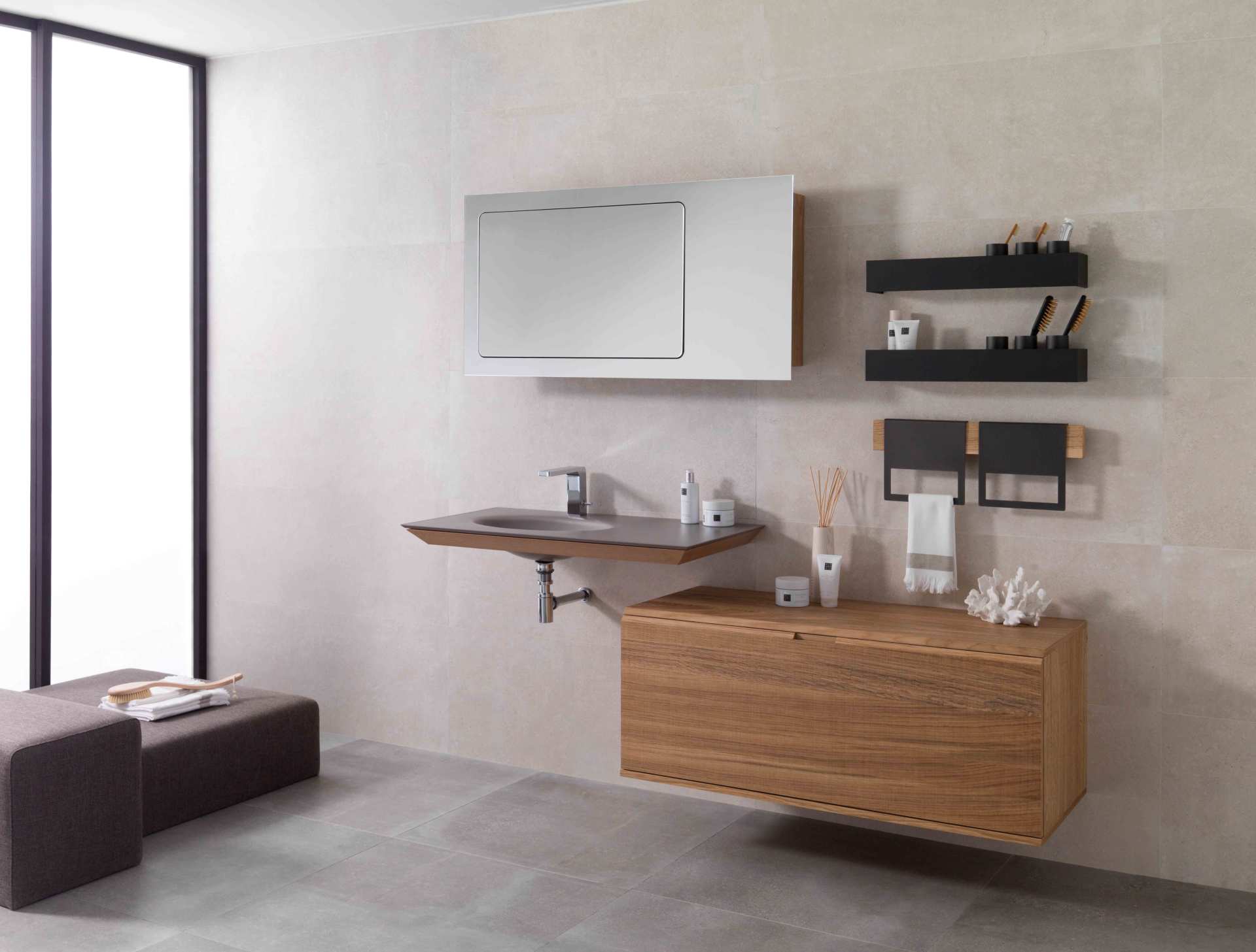 Bagno moderno e minimalista con mobile lavabo sospeso in legno, specchio con armadietto, mensole e vasca da bagno sulla sinistra.