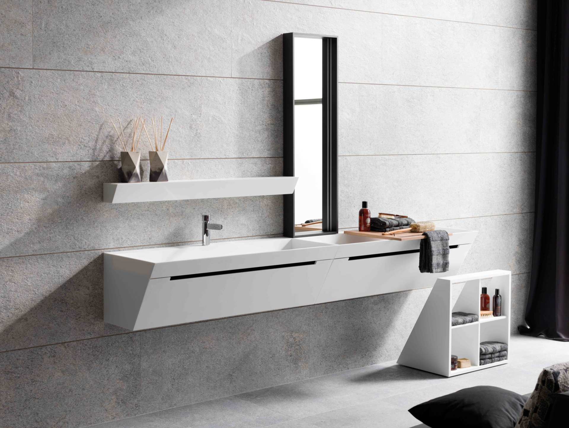 Bagno moderno con mobile lavabo sospeso bianco, armadietto con specchio e decorazioni minimaliste su parete piastrellata di grigio.