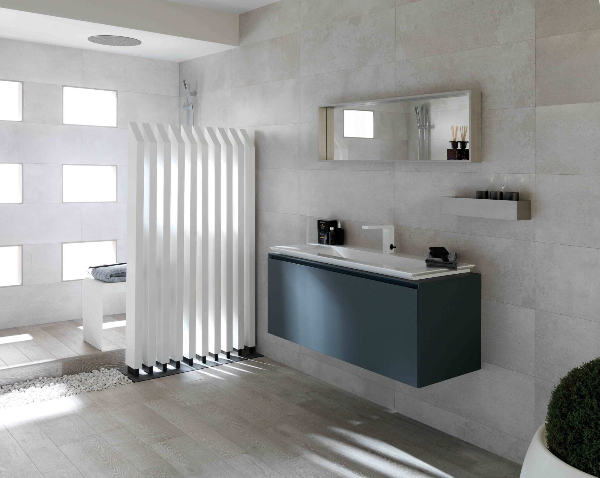 Bagno moderno e minimalista con pareti bianche, mobile lavabo sospeso, specchio, termosifone e pavimento piastrellato.