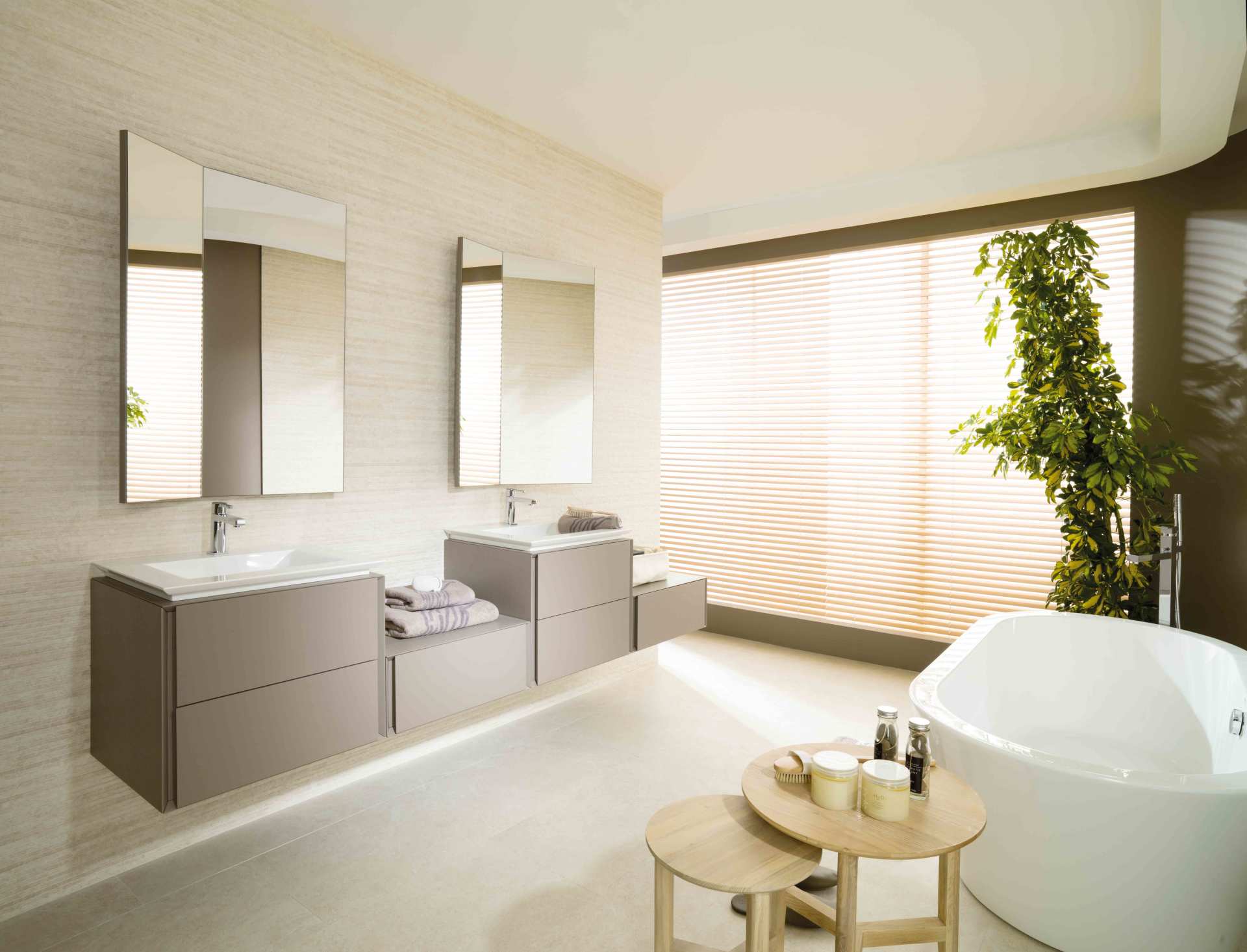 Bagno luminoso e moderno con doppio lavabo, specchi, vasca freestanding e un'ampia finestra soleggiata.