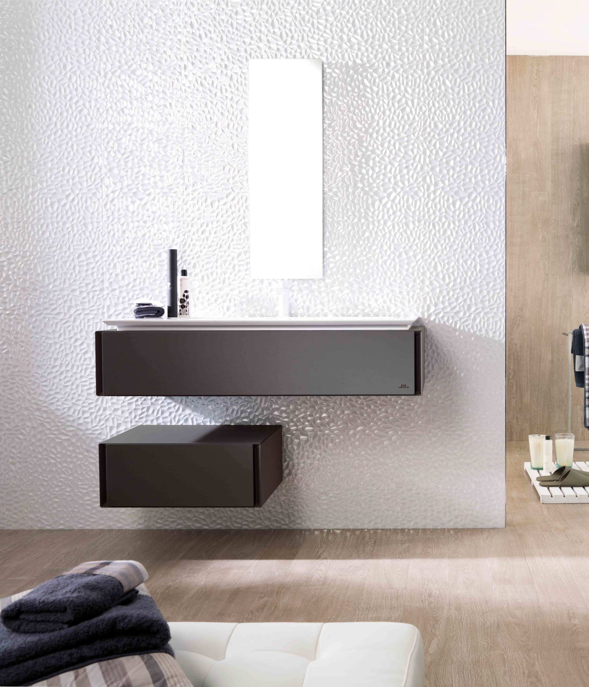 Mobile bagno moderno con lavabo sospeso scuro, specchio e parete bianca con finitura materica.