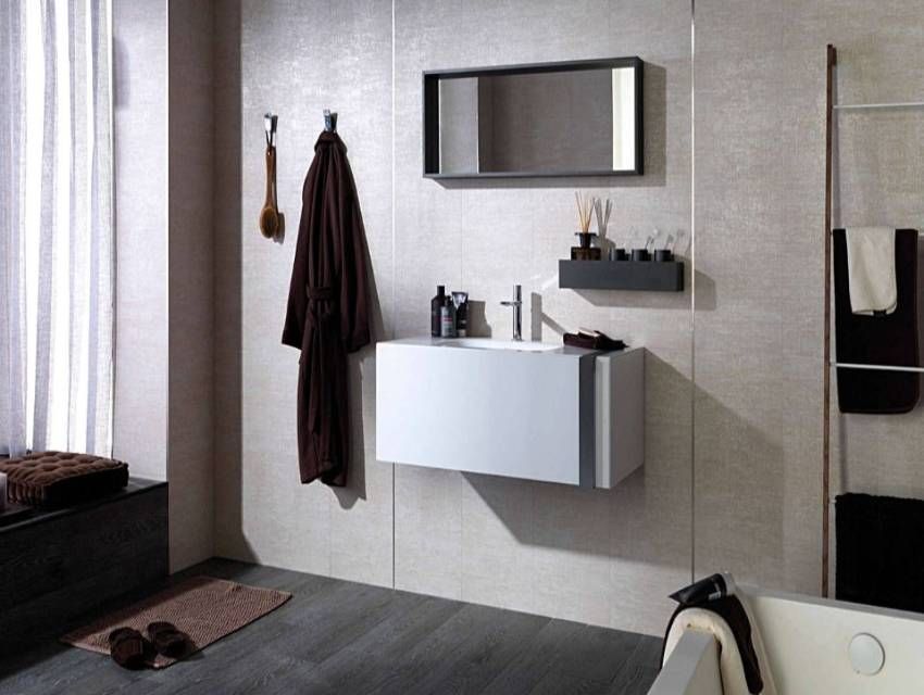 Bagno moderno con lavabo a parete, specchio, ganci per asciugamani e tenda da doccia a righe.