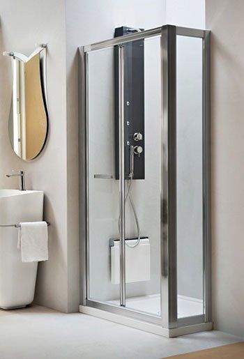 Box doccia moderno in vetro in un bagno bianco con specchio a parete e lavabo