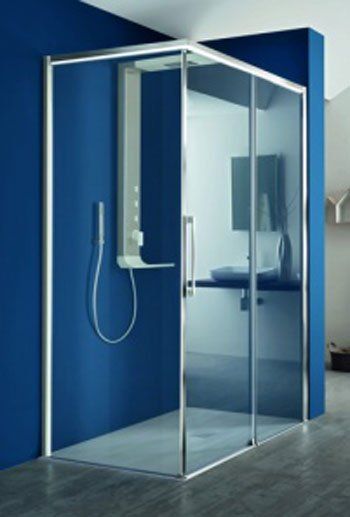 Box doccia moderno in vetro con pannelli a parete blu e telaio cromato in un bagno