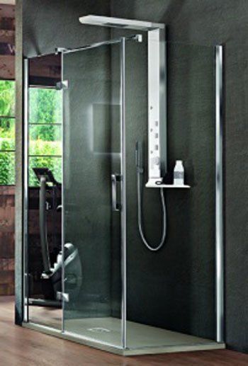 Moderna cabina doccia in vetro con soffione a pioggia e comandi a parete in un bagno grigio.