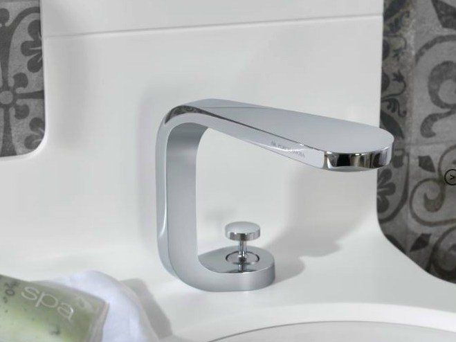 Rubinetto moderno cromato sopra un lavabo bianco in bagno