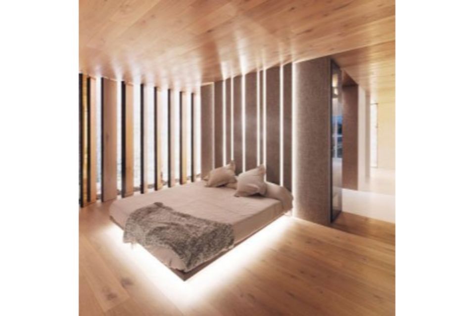 Camera da letto moderna e minimalista con soffitto in legno, doghe verticali e letto basso con illuminazione soffusa.