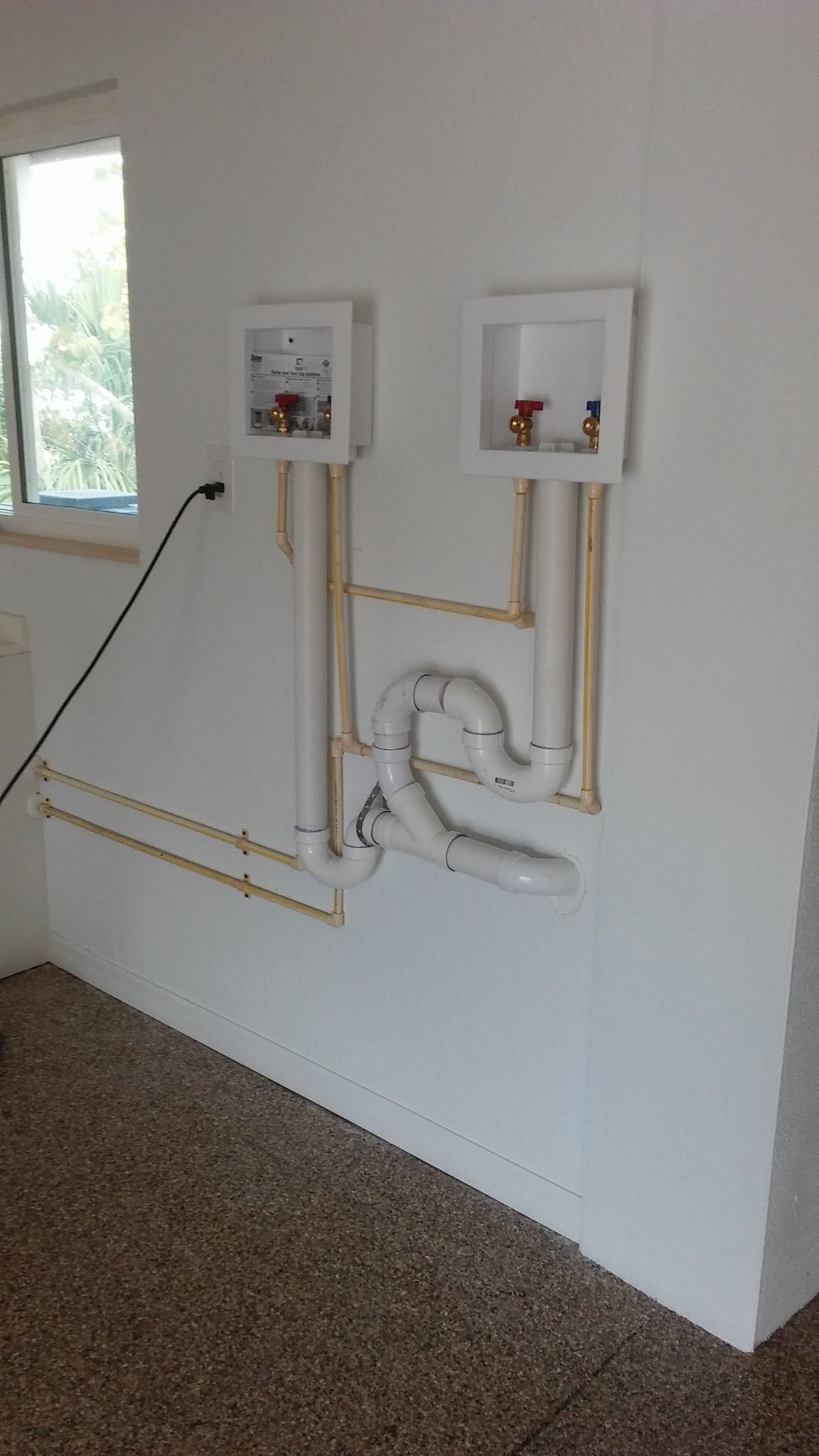 A white wall with a lot of pipes hanging from it.