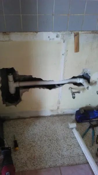 A pipe is coming out of a hole in the wall.