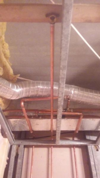 A pipe is hanging from the ceiling of a room.