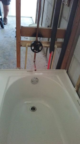 A bathtub is being installed in a bathroom under construction.