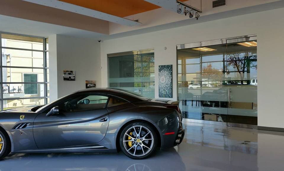 Silver sports car parked in a modern showroom with glass walls and polished floors