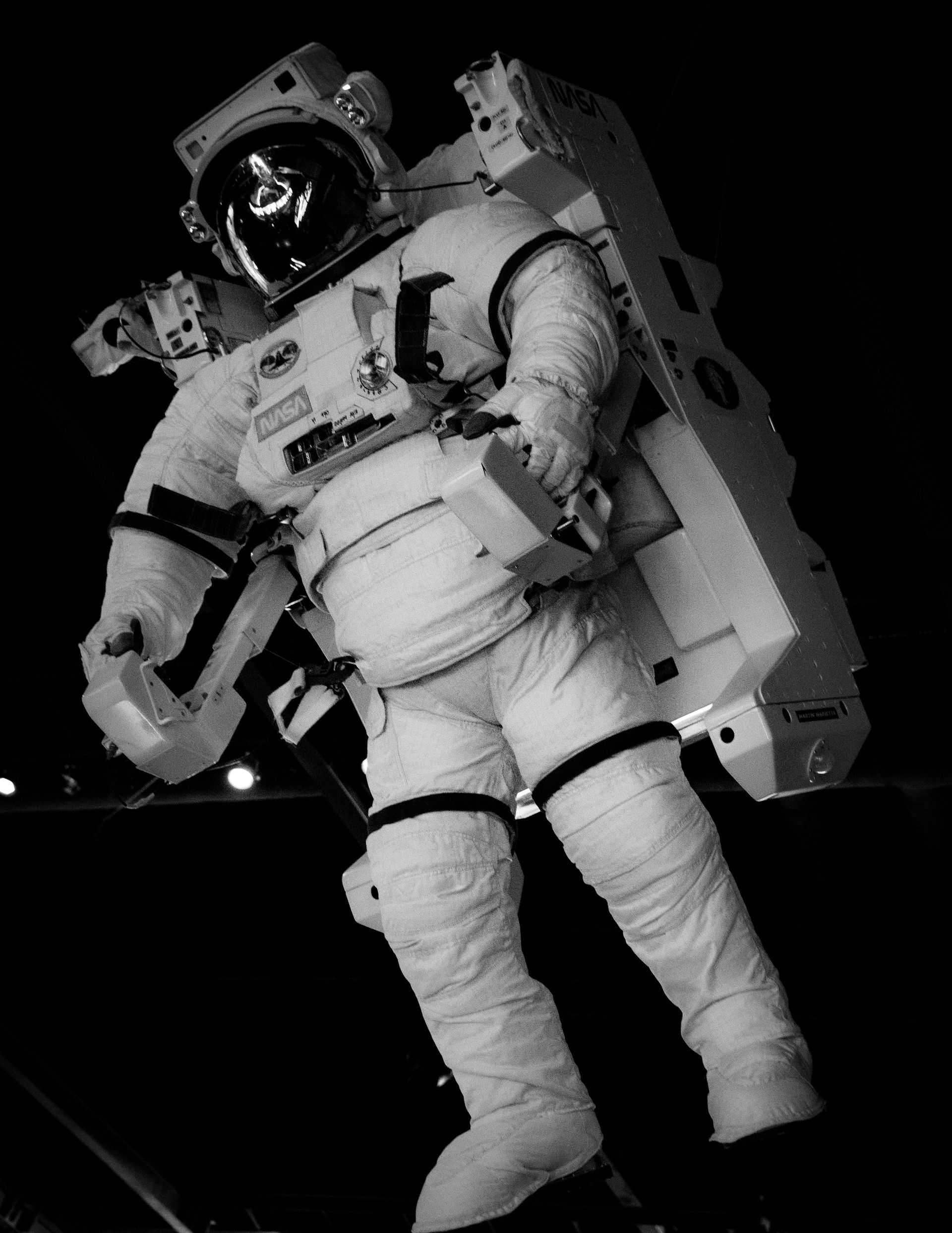 Astronaut in a white spacesuit floating in space against a black background