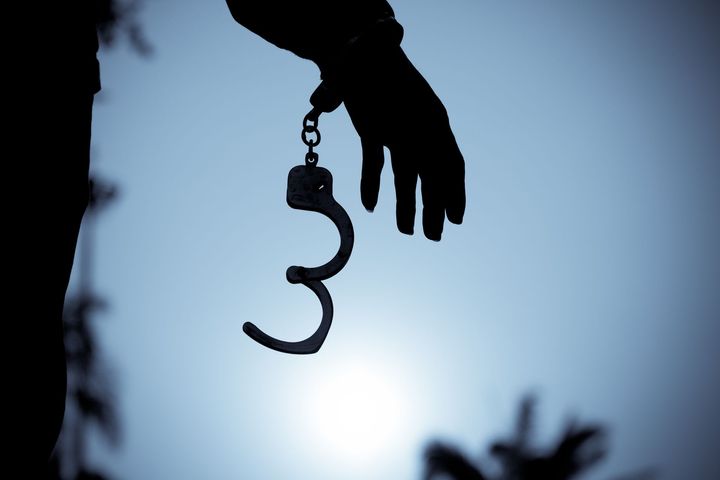 Cropped hand of men removing handcuffs.