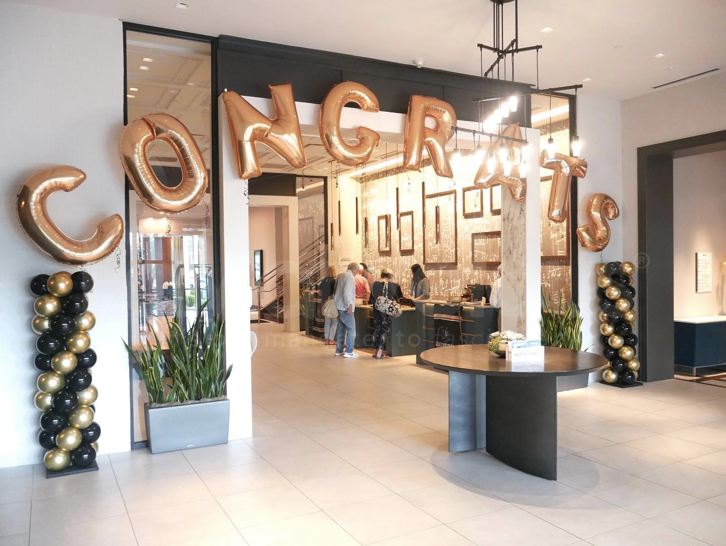 A lobby with balloons and a sign that says `` congratulations ''.