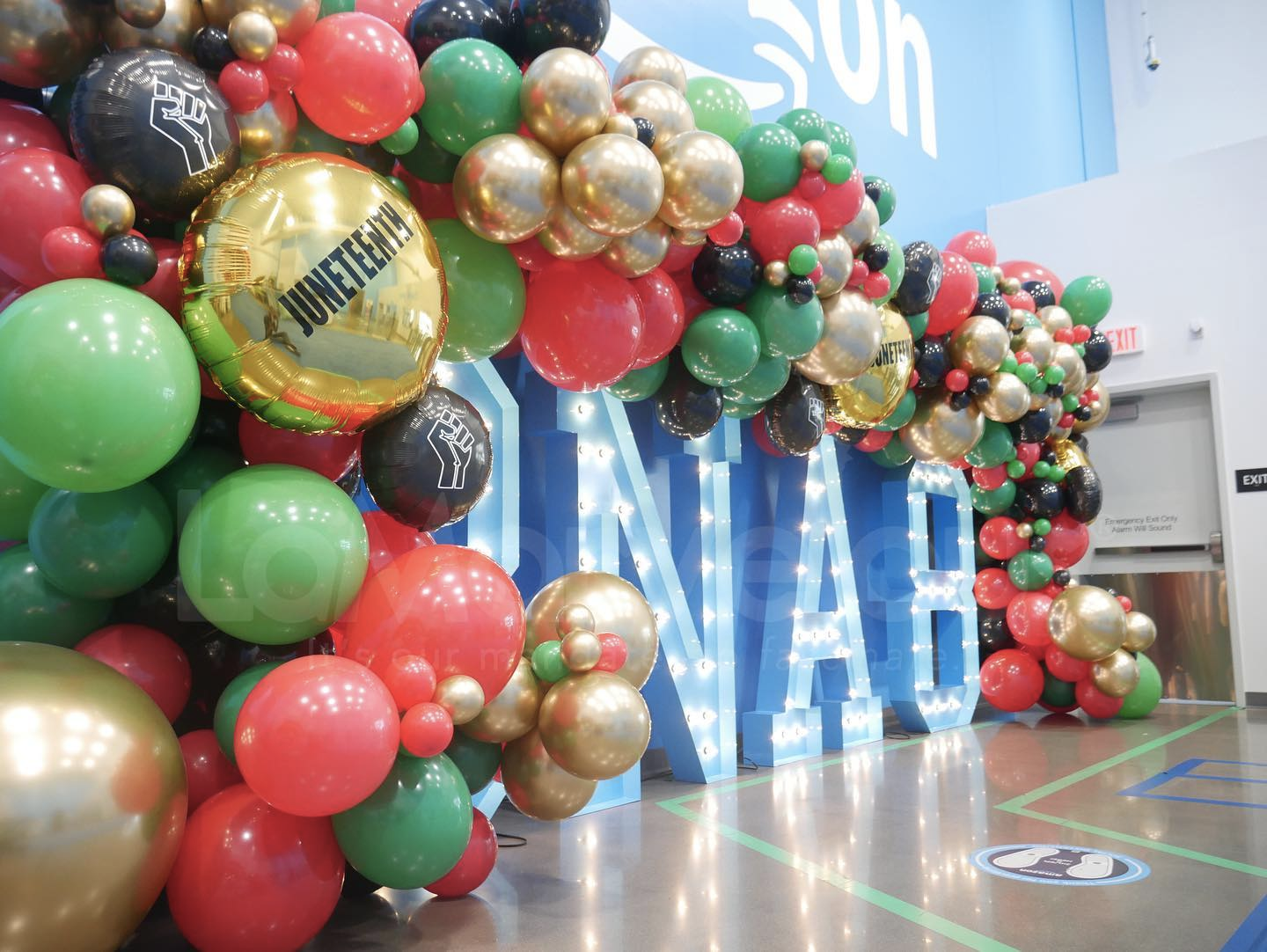 A bunch of balloons are hanging from the ceiling in a room.