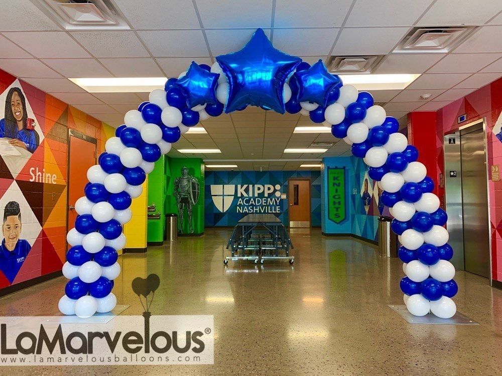 A blue and white balloon arch in a hallway