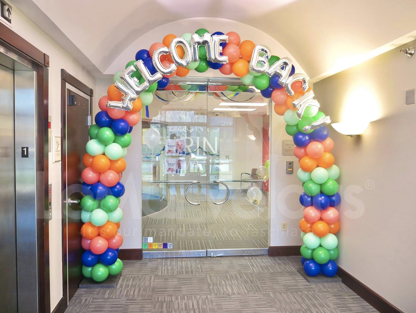 A hallway decorated with balloons and a welcome sign