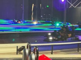 Blurred night scene with colorful neon lights streaking over a pool or water feature, viewed from a railing