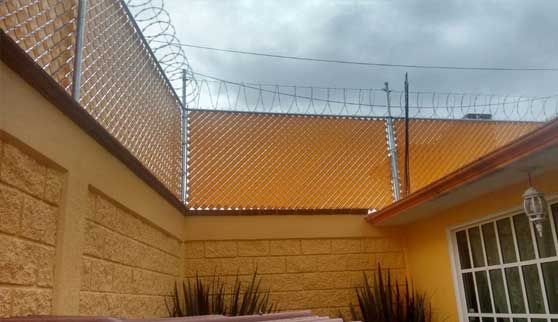Hay una cerca de alambre de púas en el patio trasero de una casa.