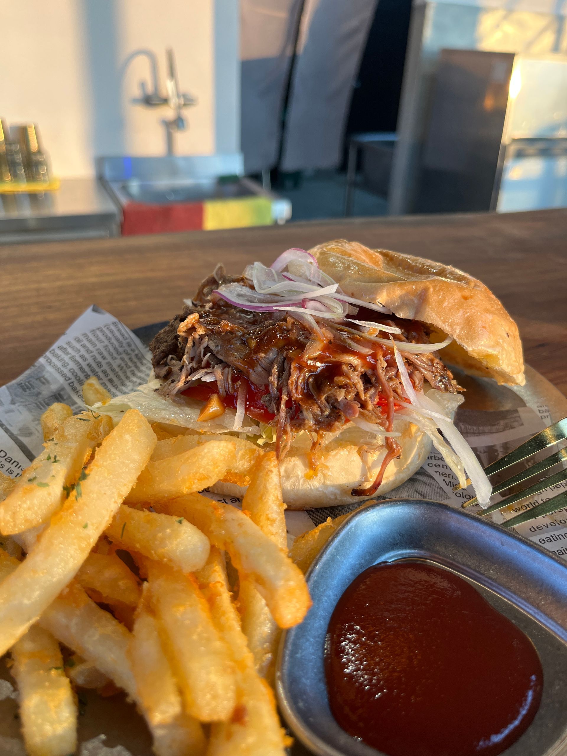 A close up of a hamburger and french fries on a table.
