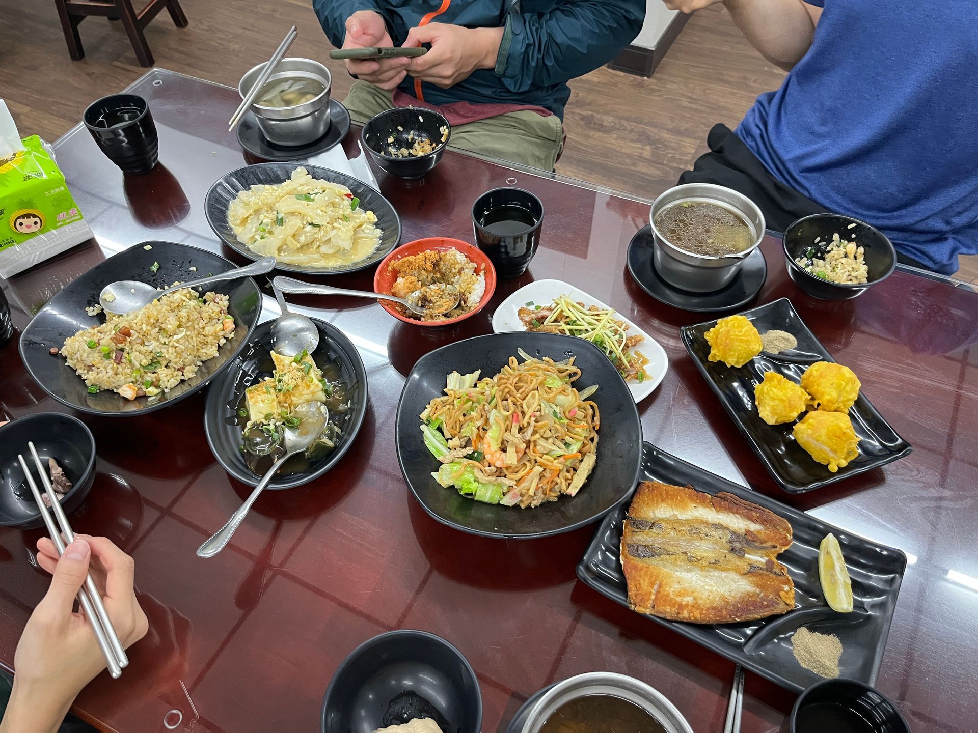 A table topped with plates of food and bowls of soup.