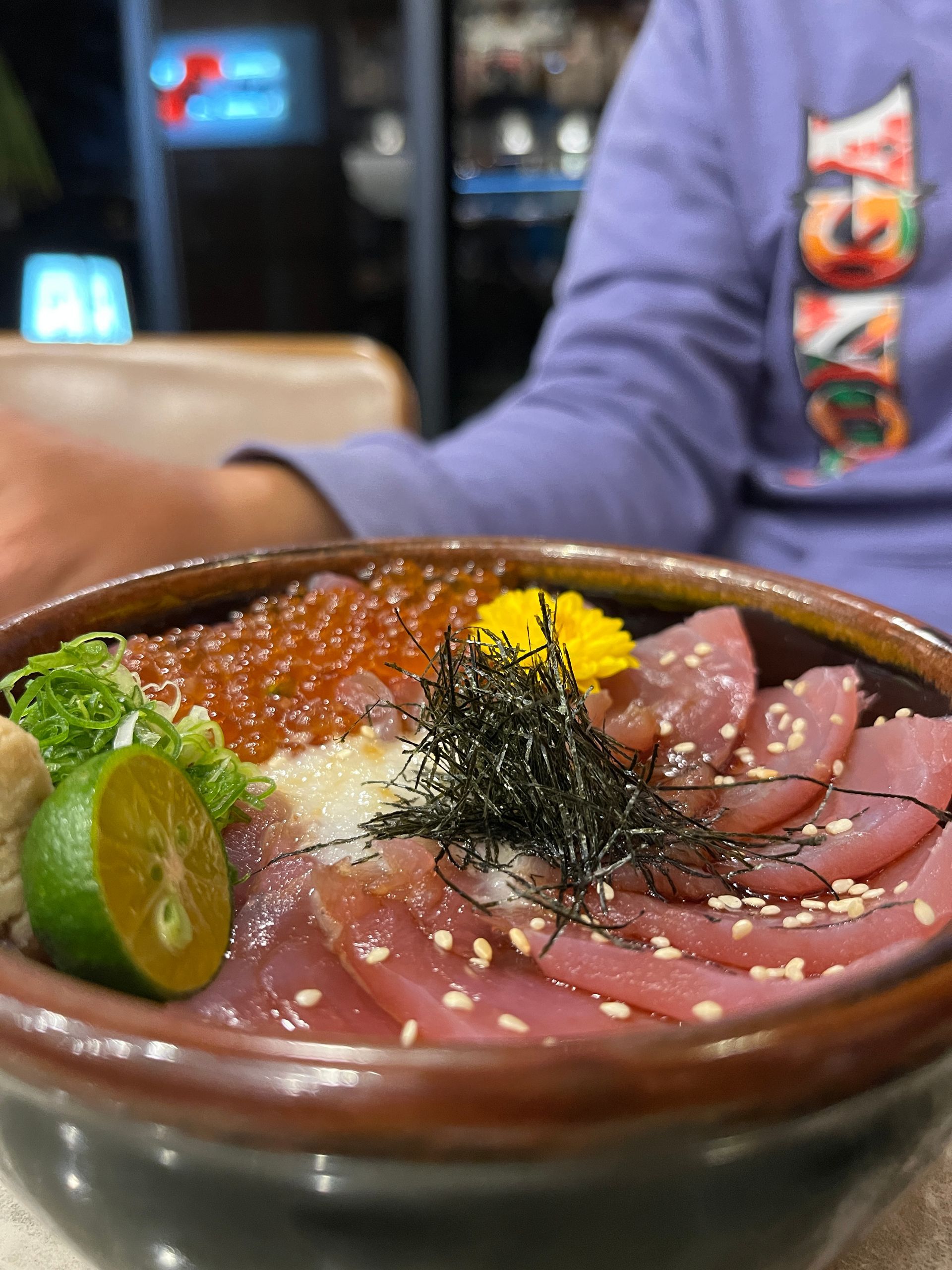 A person is sitting at a table eating a bowl of food.