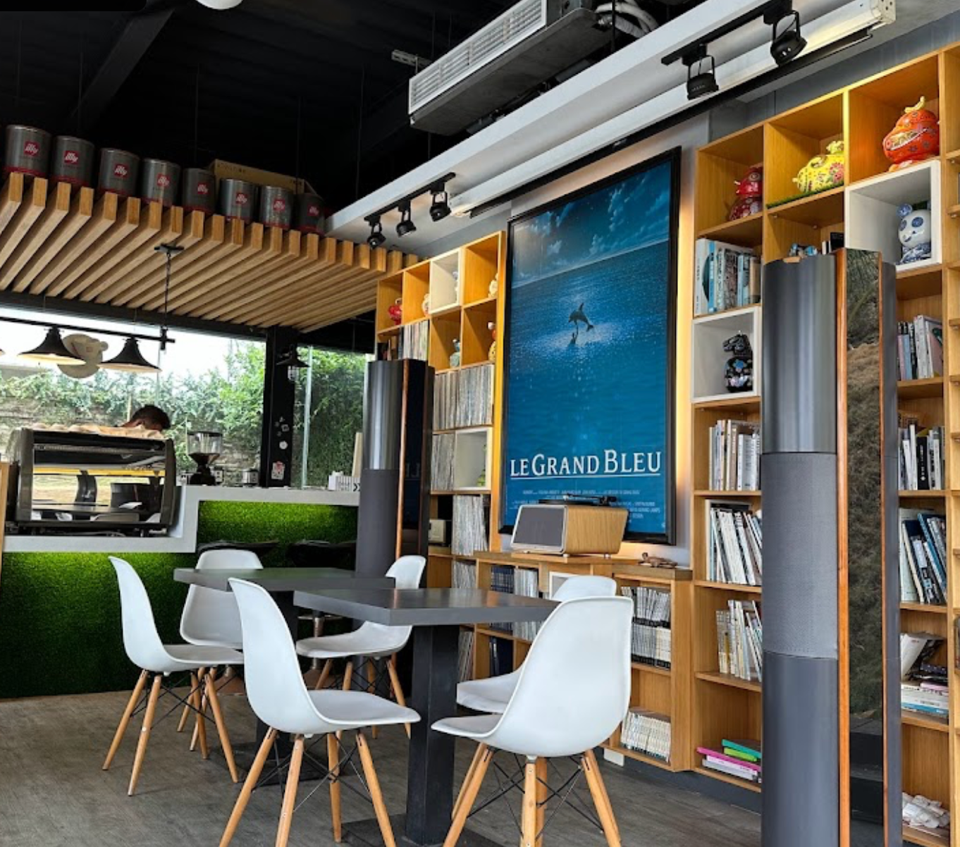 a dining room with tables and chairs and a poster on the wall that says le grand bleu