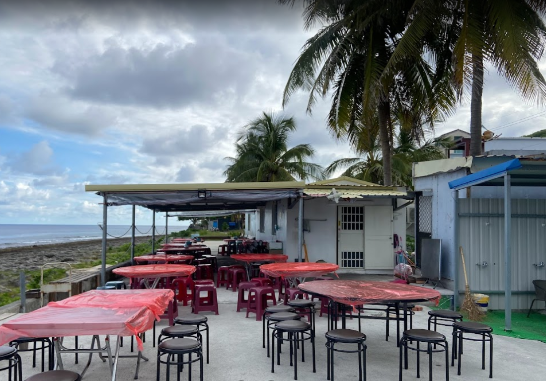 There are many tables and chairs outside of a building.